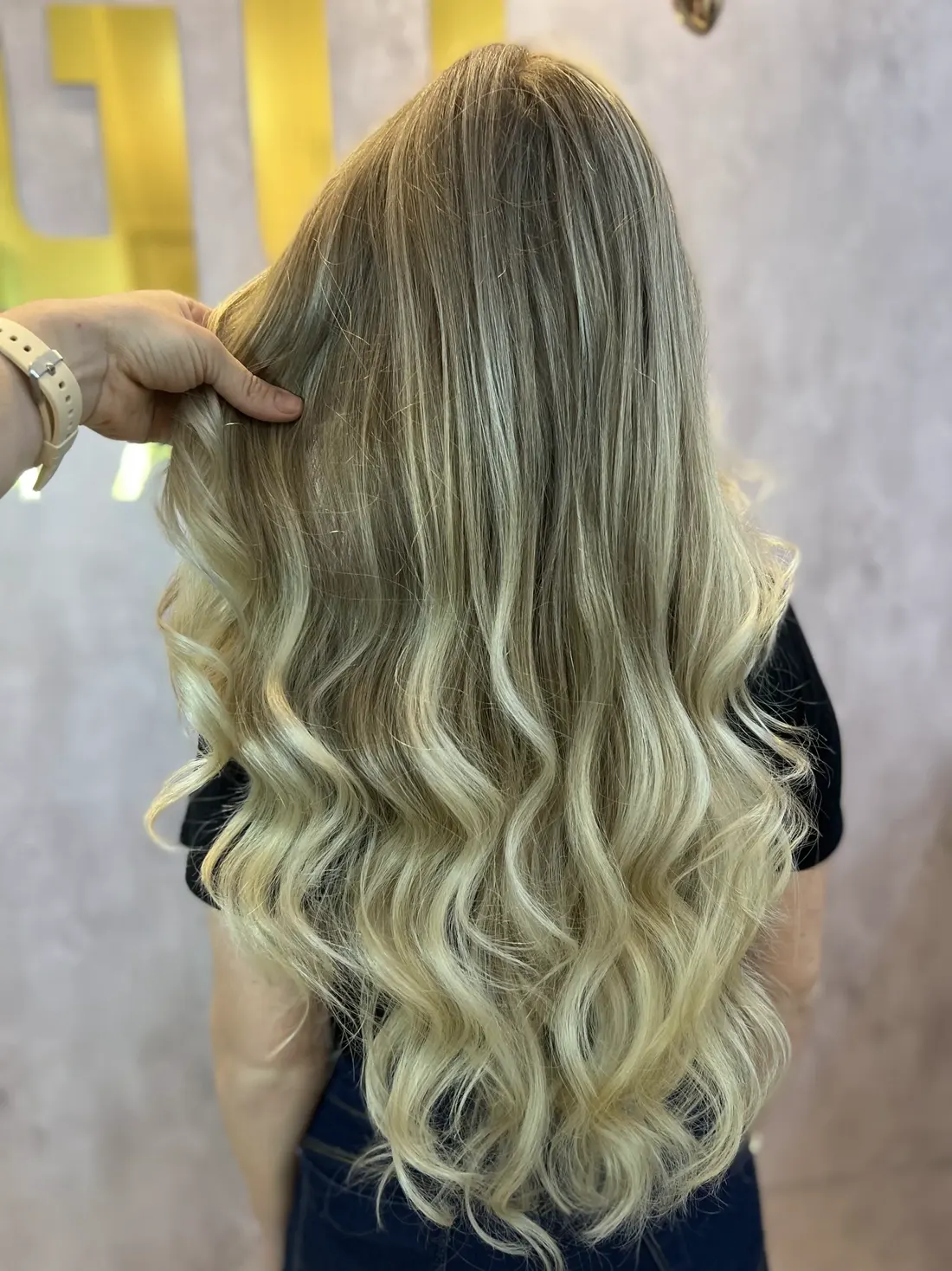 Cabeleireiro mostrando resultado de mechas loiras em cliente