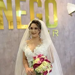 Noiva sorrindo com buquê, letreiro dourado Nego Hair ao fundo