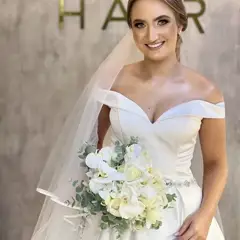 Noiva com penteado coque baixo e buquê de flores brancas