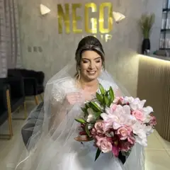 Noiva sorrindo com buquê rosa, logo Nego Hair ao fundo