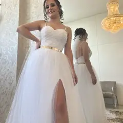 Noiva de vestido posando em frente a espelho com lustre dourado
